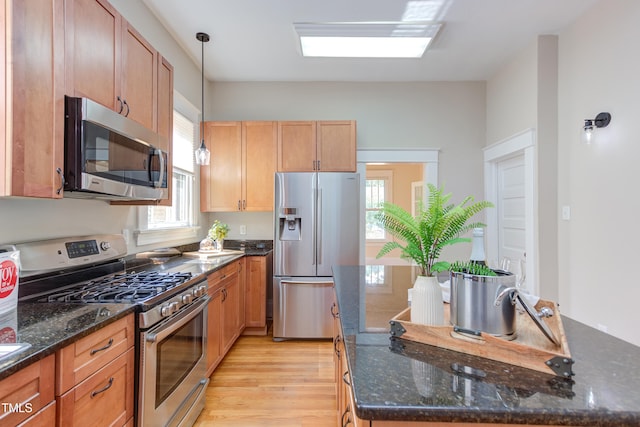 601 E Franklin St, Raleigh, NC 27604 - kitchen with appliances with stainless steel finishes, a center island, light wood-style floors, pendant lighting, and dark stone countertops
