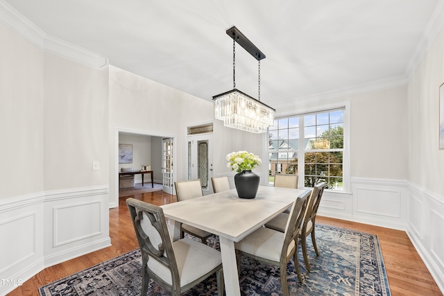 501 Ivyshaw Rd, Cary, NC 27519 - dining space with a chandelier, light wood-style floors, ornamental molding, a wainscoted wall, and french doors