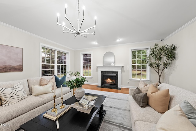 501 Ivyshaw Rd, Cary, NC 27519 - living room featuring crown molding, a chandelier, a fireplace with flush hearth, and wood finished floors