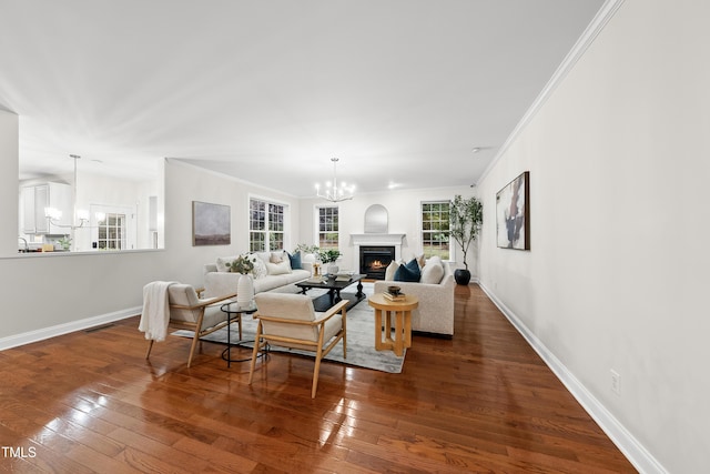 501 Ivyshaw Rd, Cary, NC 27519 - living area with a chandelier, a lit fireplace, ornamental molding, and dark wood finished floors