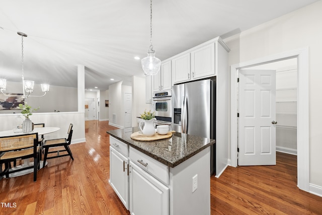 501 Ivyshaw Rd, Cary, NC 27519 - kitchen featuring wood finished floors, a chandelier, white cabinets, a kitchen island, and appliances with stainless steel finishes