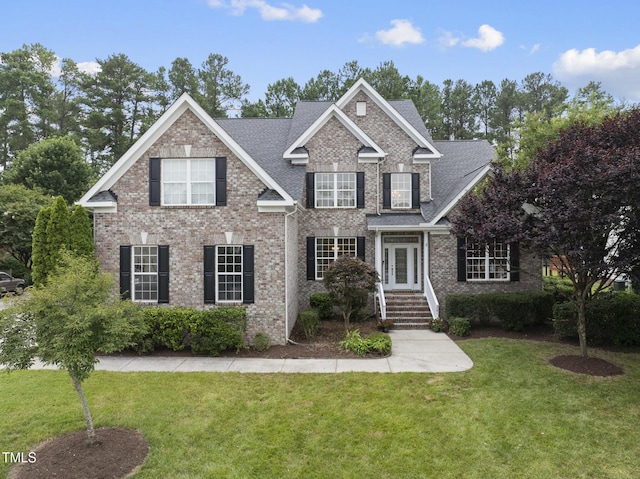 501 Ivyshaw Rd, Cary, NC 27519 - view of front facade featuring a front lawn, brick siding, and roof with shingles