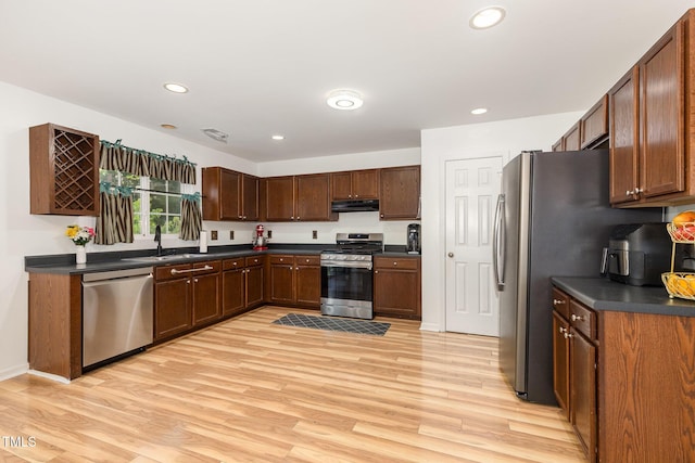 128 Palmdale Ct, Holly Springs, NC 27540 - kitchen featuring appliances with stainless steel finishes, range hood, dark countertops, light wood finished floors, and recessed lighting