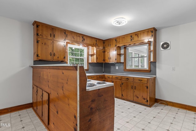 2291 Gentry Ridge Rd, Roxboro, NC 27574 - kitchen with brown cabinetry, a peninsula, light countertops, and light floors