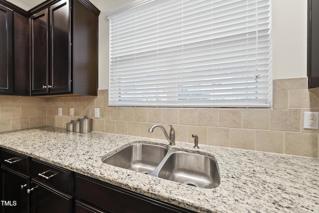 7235 Terregles Dr, Raleigh, NC 27617 - kitchen featuring backsplash, light stone countertops, dark brown cabinetry, and healthy amount of natural light