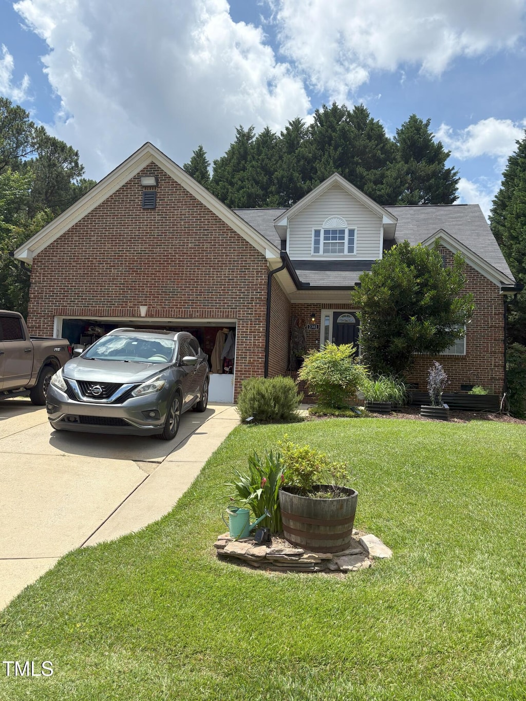 2302 Fordcrest Dr, Apex, NC 27502 - view of front of home featuring brick siding, an attached garage, driveway, and a front yard