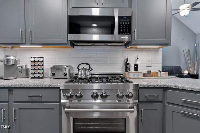 2302 Fordcrest Dr, Apex, NC 27502 - kitchen with appliances with stainless steel finishes, gray cabinetry, backsplash, and light stone counters