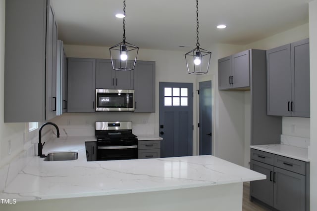 4511 Denfield St, Durham, NC 27704 - kitchen with stainless steel appliances, gray cabinets, light stone counters, a peninsula, and recessed lighting