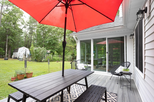 404 Denton St, Durham, NC 27713 - wooden deck featuring outdoor dining area, a storage unit, a lawn, and a sunroom