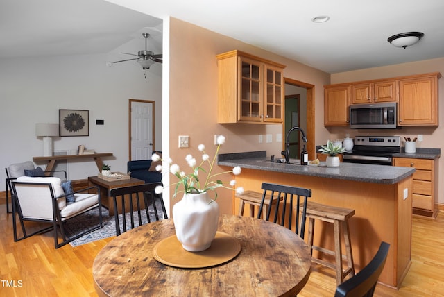 404 Denton St, Durham, NC 27713 - kitchen with appliances with stainless steel finishes, dark countertops, ceiling fan, light wood-style flooring, and vaulted ceiling