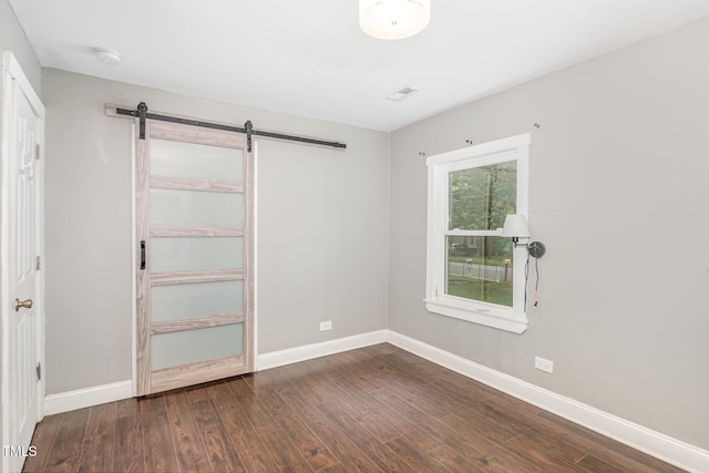 1401 Robinhood Rd, Durham, NC 27701 - unfurnished bedroom featuring a barn door, wood finished floors, and a closet