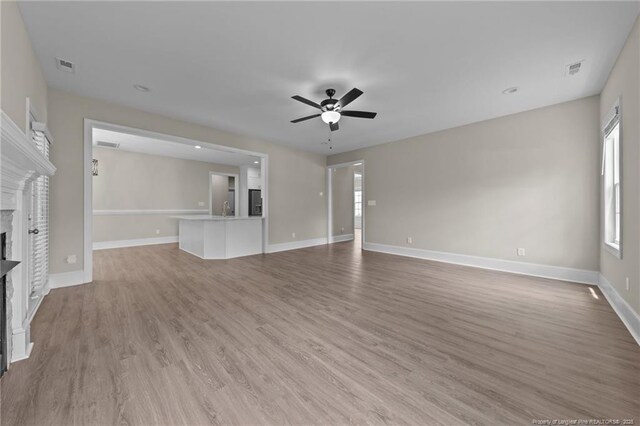 507 Coxwold Pl, Fayetteville, NC 28311 - unfurnished living room featuring a fireplace, ceiling fan, and light wood-type flooring