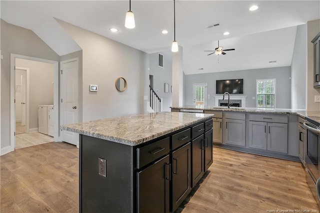 209 Nairn St, Fayetteville, NC 28311 - kitchen featuring washing machine and dryer, a ceiling fan, light wood finished floors, light stone countertops, and a peninsula