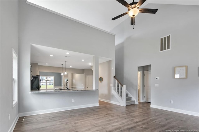 209 Nairn St, Fayetteville, NC 28311 - unfurnished living room with a high ceiling, stairs, ceiling fan, wood finished floors, and recessed lighting