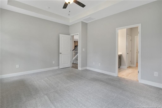 209 Nairn St, Fayetteville, NC 28311 - unfurnished bedroom with light colored carpet, a tray ceiling, and ensuite bath