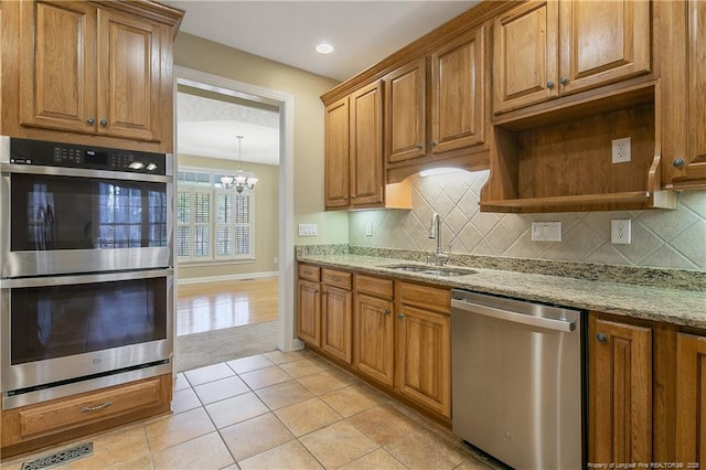 61 Fountain Park Cir, Spring Lake, NC 28390 - kitchen featuring appliances with stainless steel finishes, a chandelier, decorative backsplash, light stone countertops, and light tile patterned flooring