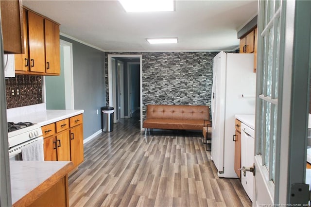 411 Rainey Dr, Spring Lake, NC 28390 - kitchen with light countertops, white appliances, light wood-style flooring, brown cabinets, and ornamental molding