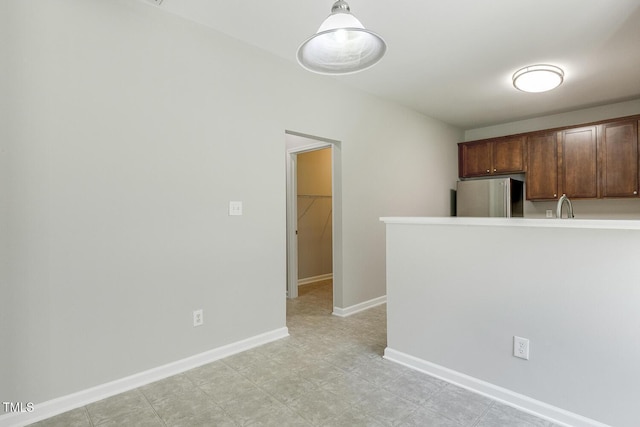 160 Chandler Springs Dr, Holly Springs, NC 27540 - kitchen with freestanding refrigerator, light countertops, a peninsula, and hanging light fixtures