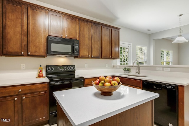 160 Chandler Springs Dr, Holly Springs, NC 27540 - kitchen featuring black appliances, a peninsula, light countertops, pendant lighting, and a center island