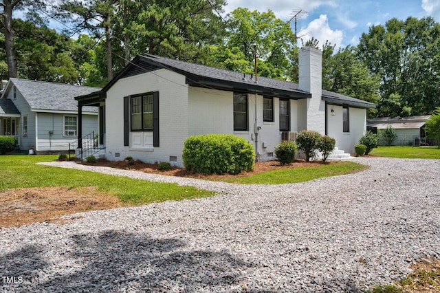 407 W Pippen St, Whitakers, NC 27891 - ranch-style house featuring crawl space, a chimney, brick siding, roof with shingles, and gravel driveway