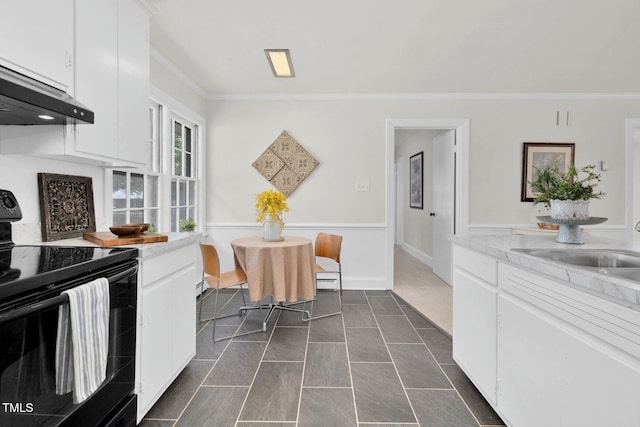 407 W Pippen St, Whitakers, NC 27891 - kitchen with black range with electric stovetop, ornamental molding, exhaust hood, white cabinetry, and light countertops