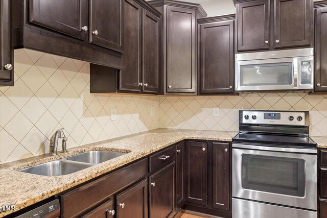 1213 Silver Beach Way, Raleigh, NC 27606 - kitchen with stainless steel appliances, dark brown cabinetry, backsplash, and light stone countertops