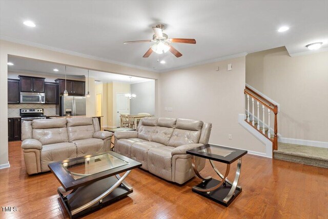 1213 Silver Beach Way, Raleigh, NC 27606 - living area with a ceiling fan, stairway, light wood-style floors, a chandelier, and ornamental molding