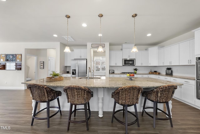 433 Village Bend Dr, Fuquay Varina, NC 27526 - kitchen with appliances with stainless steel finishes, white cabinets, dark wood finished floors, a spacious island, and recessed lighting