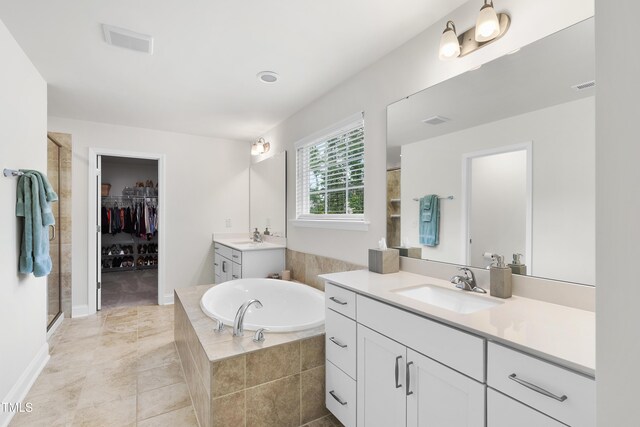 433 Village Bend Dr, Fuquay Varina, NC 27526 - bathroom featuring two vanities, a shower stall, a garden tub, and a spacious closet