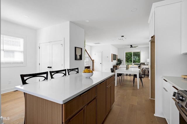 1410 Joe Louis Ave, Raleigh, NC 27610 - kitchen with light wood-style flooring, a ceiling fan, a kitchen island, light countertops, and recessed lighting