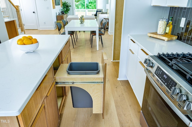 1410 Joe Louis Ave, Raleigh, NC 27610 - kitchen with stainless steel range with gas stovetop, light wood-style floors, light countertops, and decorative backsplash