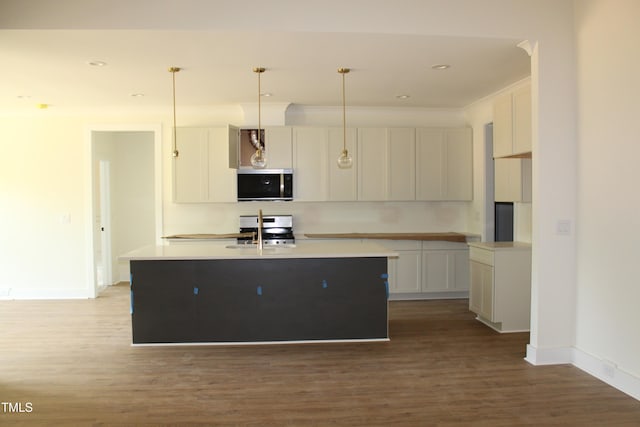 70 Basil Ct, Franklinton, NC 27525 - kitchen featuring appliances with stainless steel finishes, wood finished floors, white cabinetry, an island with sink, and recessed lighting