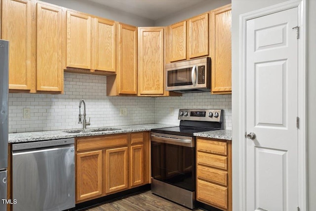 330 Gilman Ln Unit 109, Raleigh, NC 27610 - kitchen featuring appliances with stainless steel finishes, backsplash, light stone countertops, light brown cabinetry, and dark wood-style floors