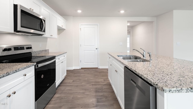 100 Grove Ln, Goldsboro, NC 27534 - kitchen with appliances with stainless steel finishes, dark wood finished floors, white cabinets, light stone counters, and a center island with sink