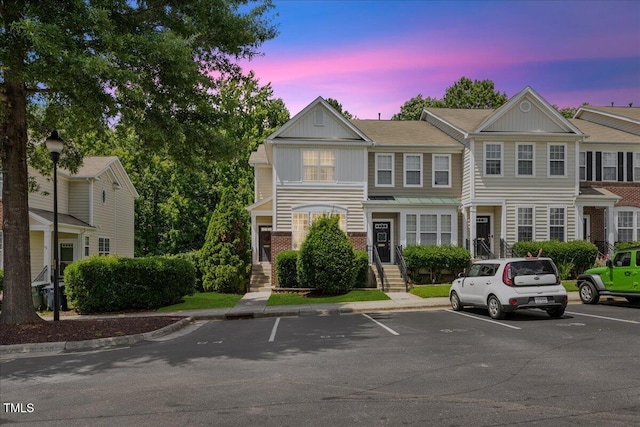 7856 Spungold St, Raleigh, NC 27617 - view of property featuring uncovered parking, board and batten siding, and brick siding