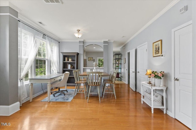 7856 Spungold St, Raleigh, NC 27617 - dining area with light wood-style flooring, ornamental molding, and arched walkways
