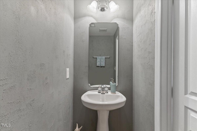 7856 Spungold St, Raleigh, NC 27617 - bathroom featuring a textured wall and a chandelier