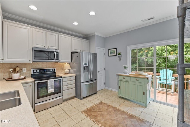 7856 Spungold St, Raleigh, NC 27617 - kitchen featuring stainless steel appliances, backsplash, white cabinets, light tile patterned floors, and crown molding