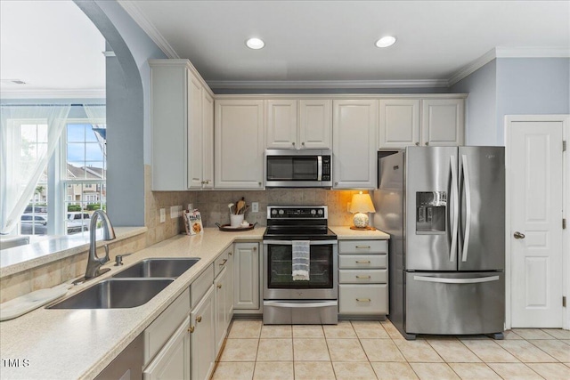7856 Spungold St, Raleigh, NC 27617 - kitchen with appliances with stainless steel finishes, ornamental molding, light countertops, tasteful backsplash, and light tile patterned floors