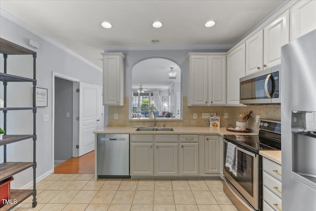 7856 Spungold St, Raleigh, NC 27617 - kitchen with appliances with stainless steel finishes, ornamental molding, light countertops, decorative backsplash, and light tile patterned flooring