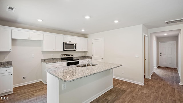105 Grove Ln, Goldsboro, NC 27534 - kitchen with stainless steel appliances, wood finished floors, white cabinetry, a kitchen island with sink, and recessed lighting