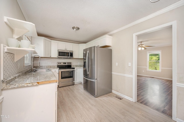 816 Kimpton Ct, Fuquay Varina, NC 27526 - kitchen with appliances with stainless steel finishes, open shelves, light wood finished floors, backsplash, and white cabinets