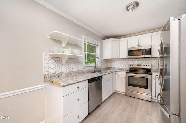 816 Kimpton Ct, Fuquay Varina, NC 27526 - kitchen with appliances with stainless steel finishes, crown molding, light wood-type flooring, and white cabinets