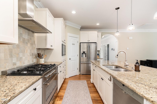 6 Tulip Tree Ct, Durham, NC 27712 - kitchen with stainless steel appliances, wall chimney range hood, arched walkways, ornamental molding, and white cabinets