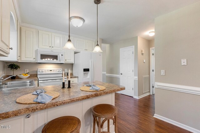 86 Basswood Cir, Willow Springs, NC 27592 - kitchen with white appliances, a kitchen bar, dark wood-style floors, pendant lighting, and white cabinets