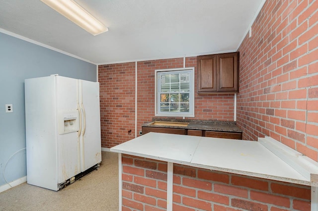 5917 Meadowlark Ln, Raleigh, NC 27610 - kitchen with white refrigerator with ice dispenser, brick wall, ornamental molding, and a peninsula