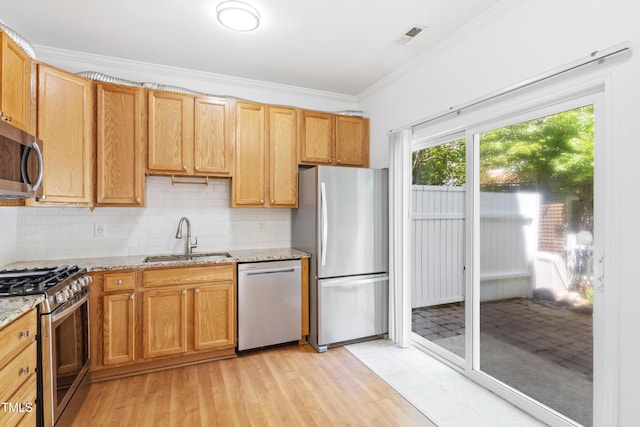 11710 Mezzanine Dr Unit 101, Raleigh, NC 27614 - kitchen with stainless steel appliances, ornamental molding, decorative backsplash, light stone counters, and light wood-type flooring