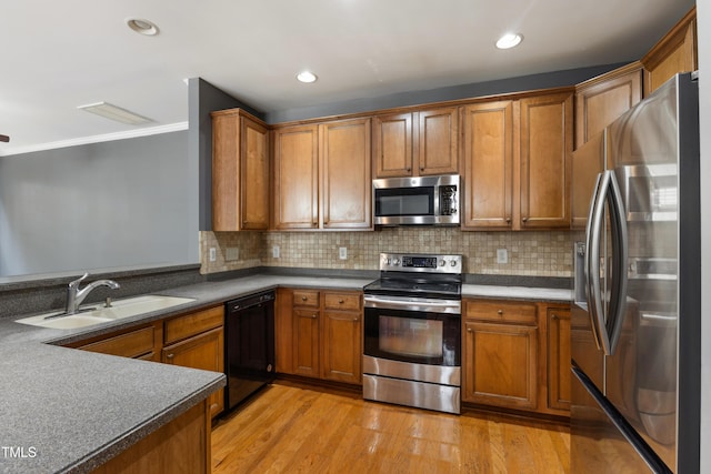 5503 Silver Moon Ln, Raleigh, NC 27606 - kitchen featuring appliances with stainless steel finishes, brown cabinetry, ornamental molding, light wood-style flooring, and backsplash