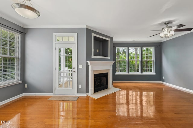 5503 Silver Moon Ln, Raleigh, NC 27606 - unfurnished living room with healthy amount of natural light, ceiling fan, wood finished floors, a premium fireplace, and ornamental molding