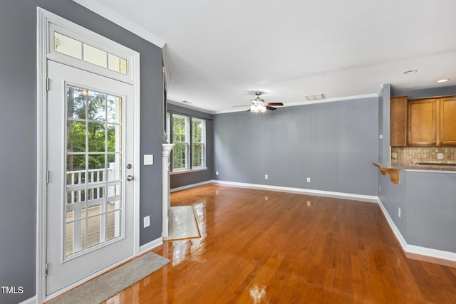 5503 Silver Moon Ln, Raleigh, NC 27606 - unfurnished living room featuring wood finished floors, a ceiling fan, crown molding, and recessed lighting